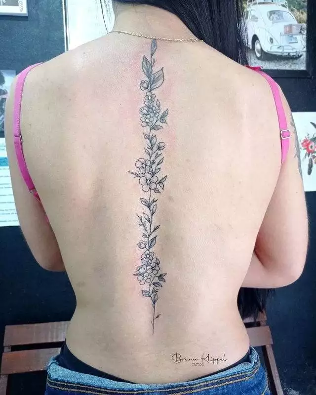 mulher com as costas tatuada