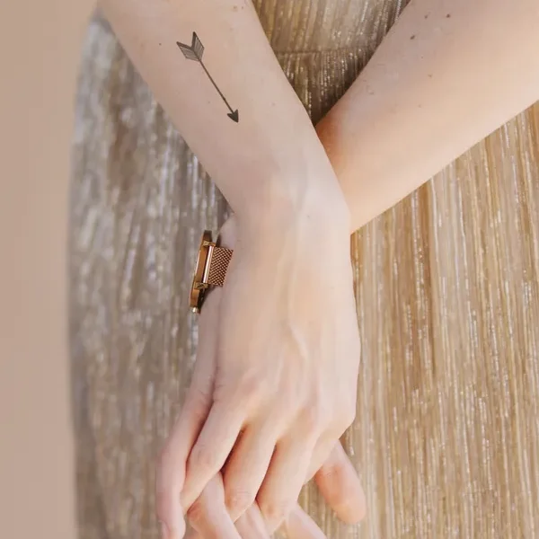 braços tatuados com flecha