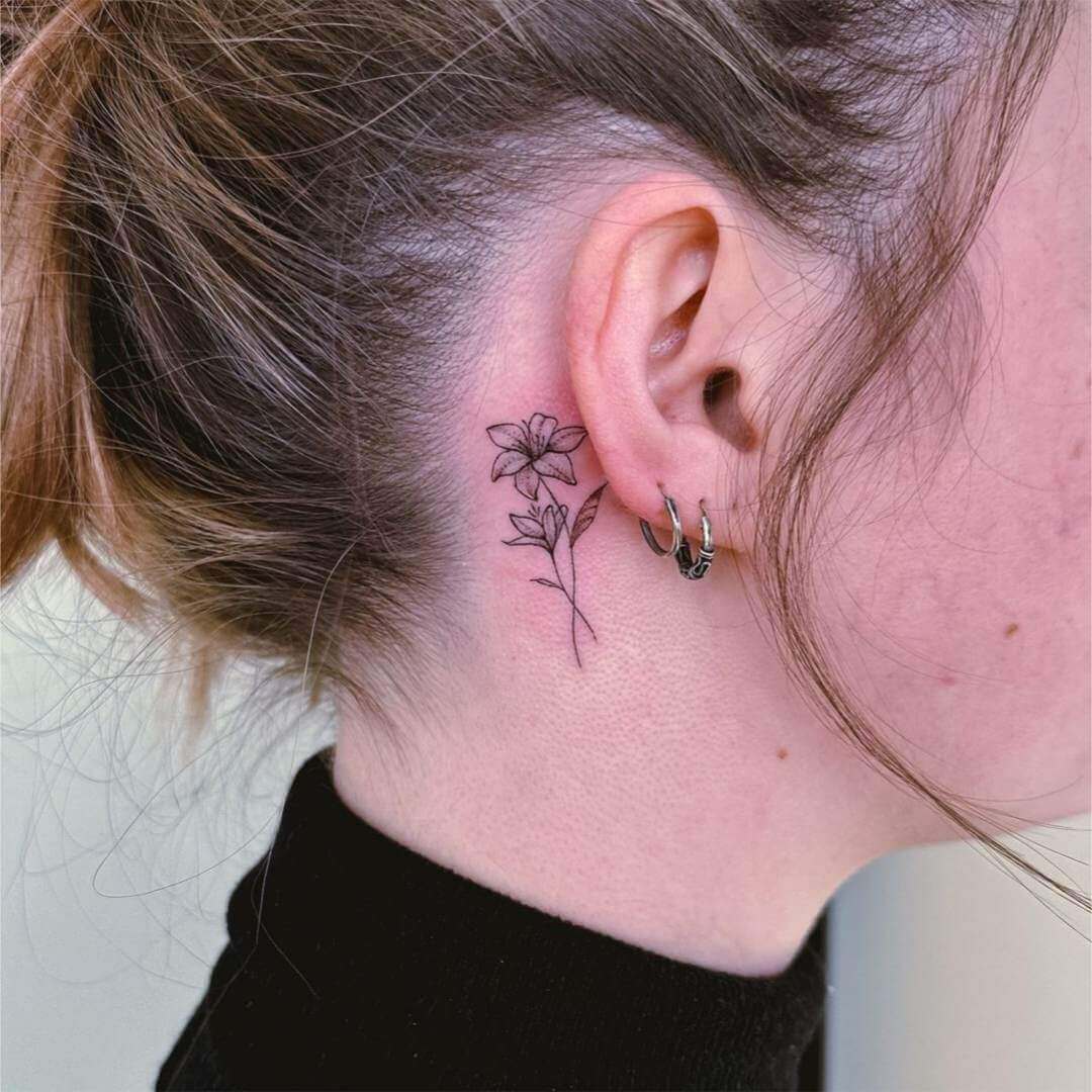 tattoo delicada flor atrás da orelha