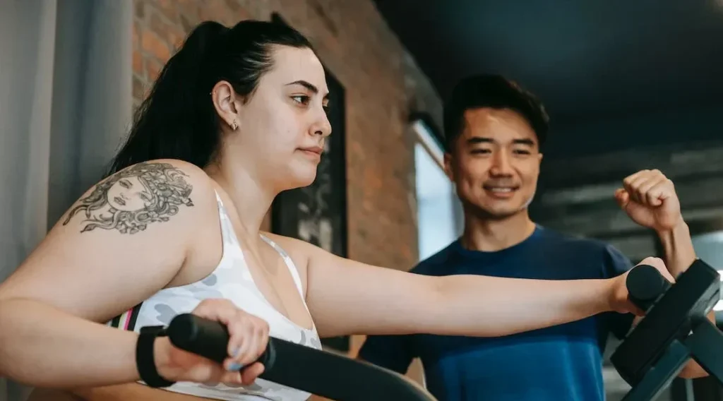 mulher tatuada fazendo exercícios em referência a relação entre tatuagem e exercícios físicos