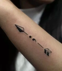Tatuagem de ponto e vírgula com sinais que o transformam em uma flecha