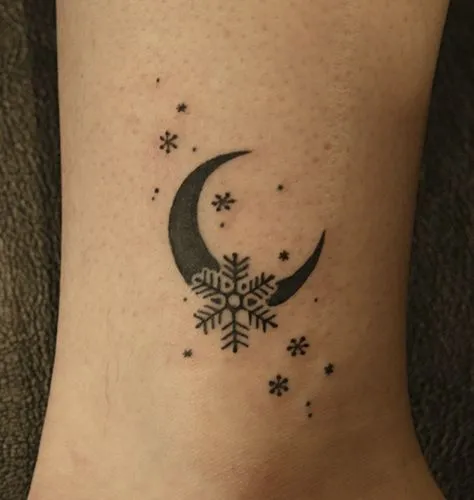 Tatuagem de um floco de neve com uma lua atrás