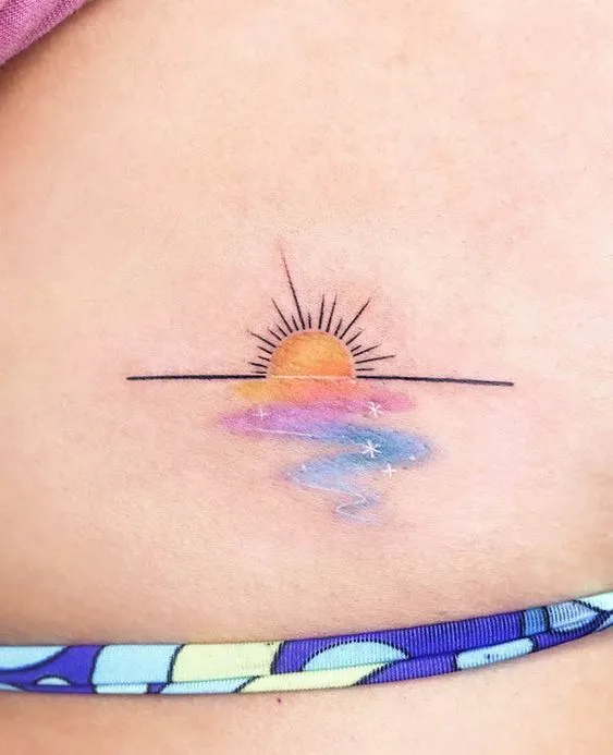 Tatuagem fineline e aquarelada de um sol no horizonte