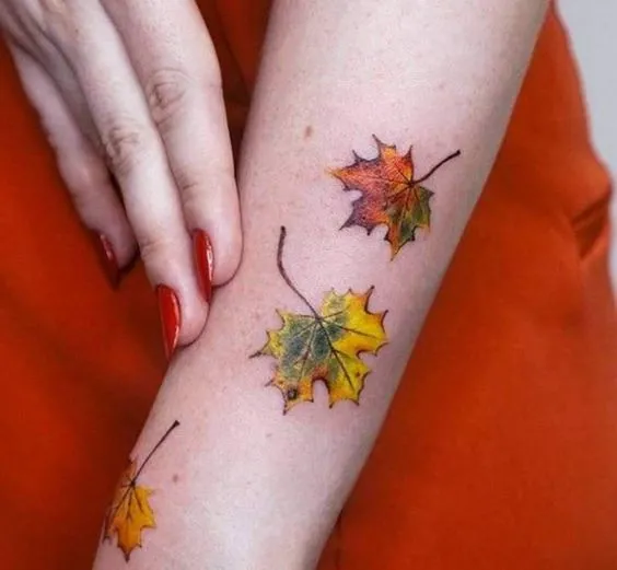 Tatuagem de folhas verdes e laranjas