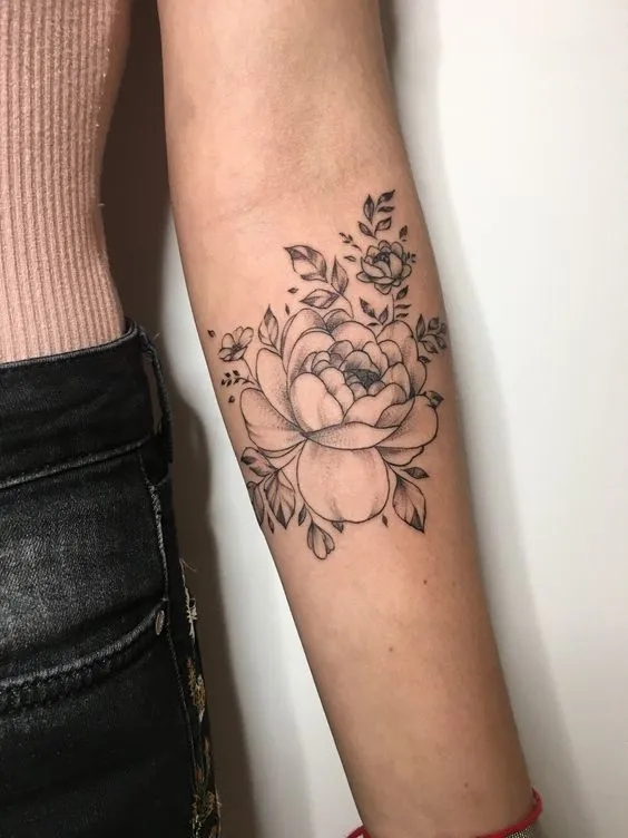 Tatuagem no antebraço de flores delicadas