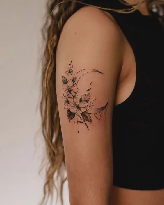 Tatuagem floral com uma lua ao fundo