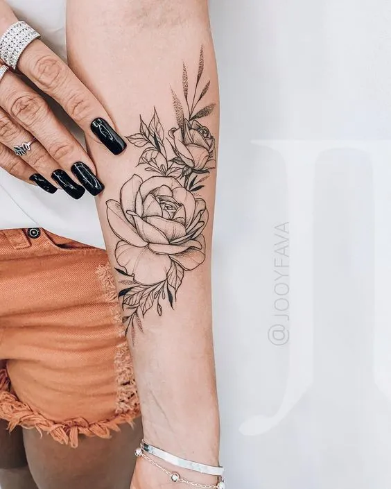 Tatuagem floral em braço feminino linhas finas