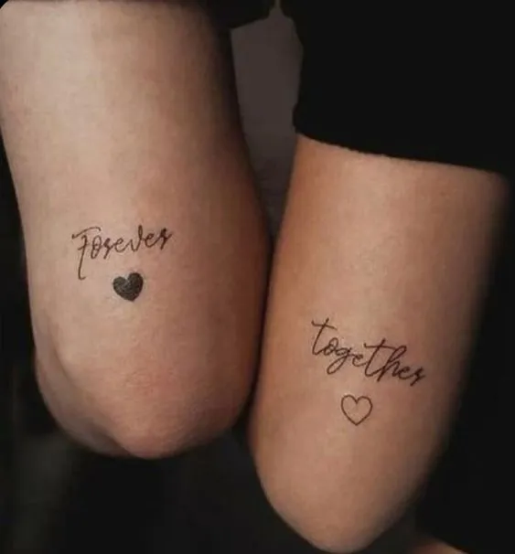 Tatuagem de casal com um coração escrito "Together"