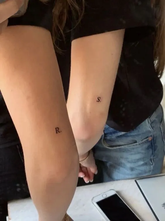 Tatuagem de casal mini feito acima do cotovelo