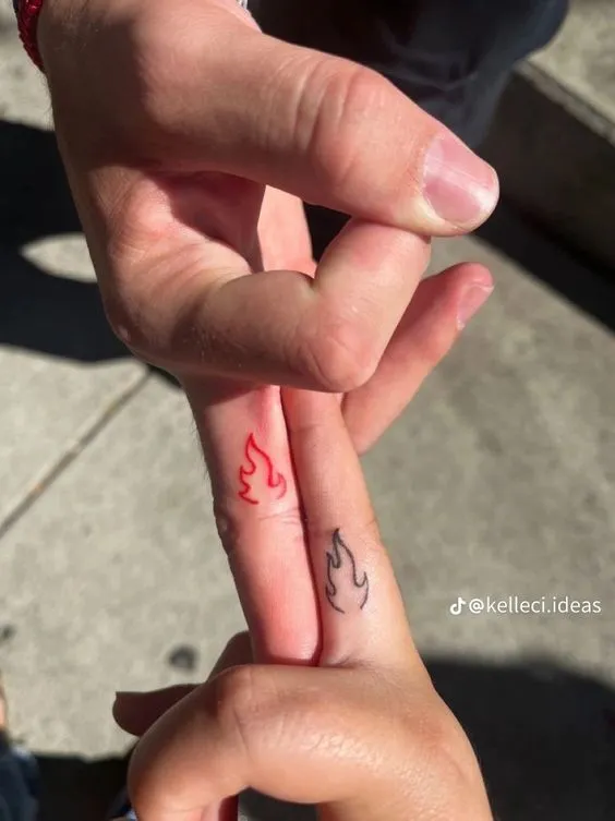 Tatuagem de fogo nos dedos do meio