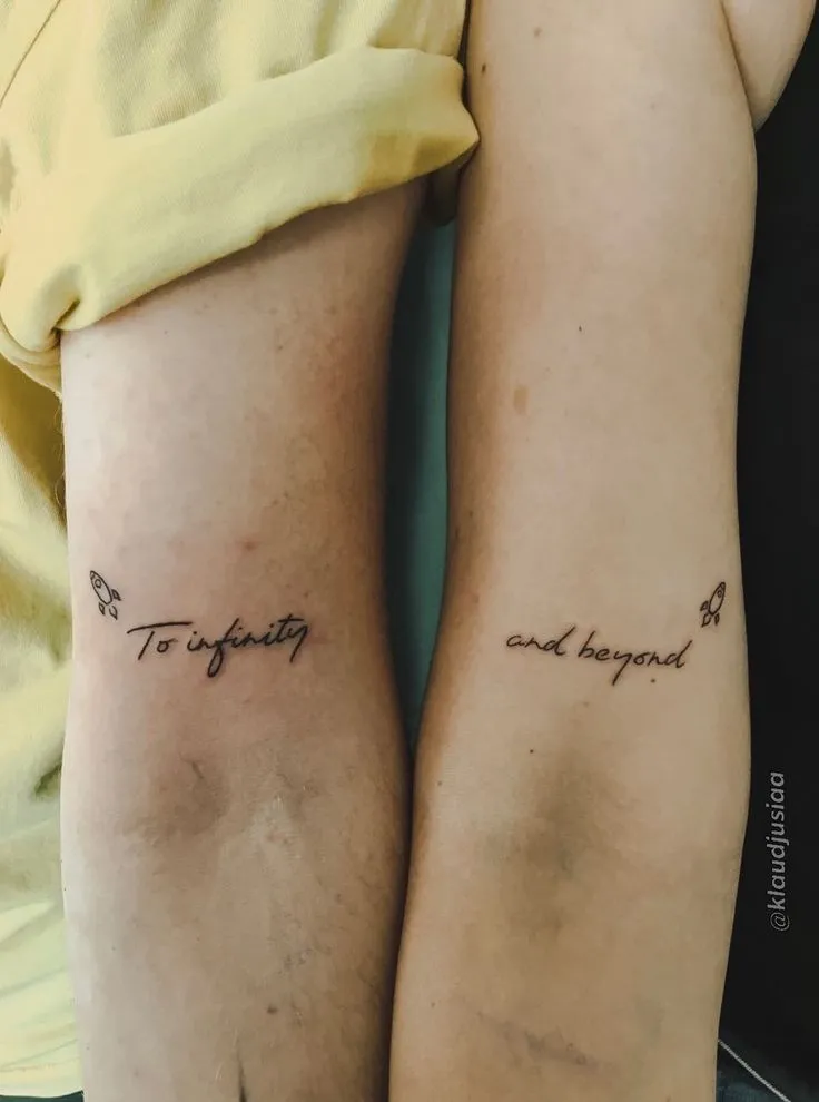 Tatuagem de casal onde em um braço está escrito "To infinity" e no outro "and beyond"