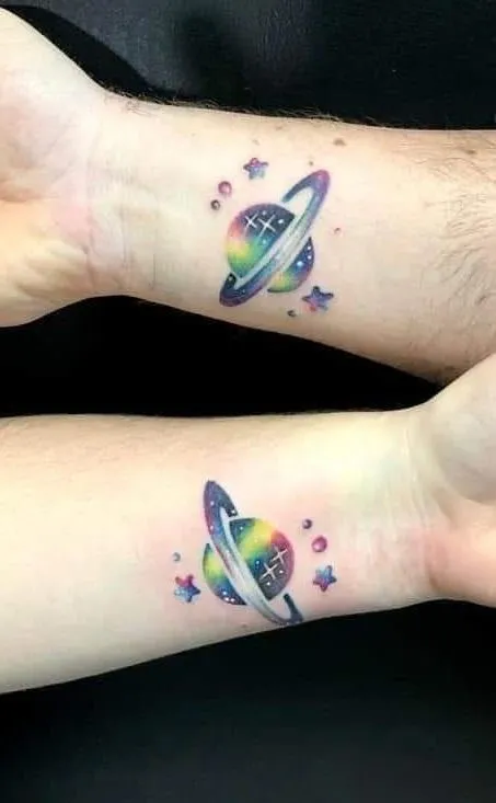 Tatuagem de saturno feita no pulso