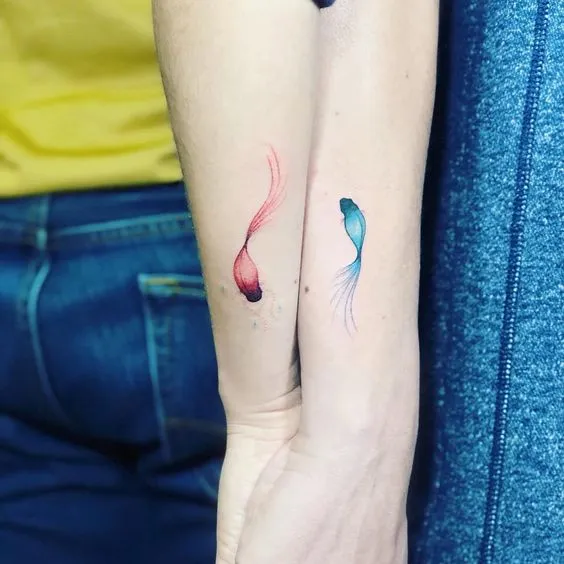 tatuagem de casal onde cada braço tem um peixinho