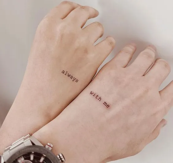 Tatuagem de casal onde em uma mão está "Always" e na outra "With me"