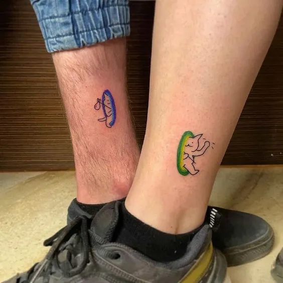 tatuagem de casal inspirada no jogo Portal, na arte cada um tem um portal com um gatinho saindo de dentro dele