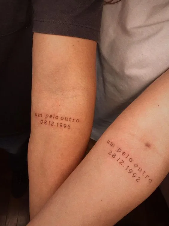 tatuagem de casal com data e escrito "um pelo outro"