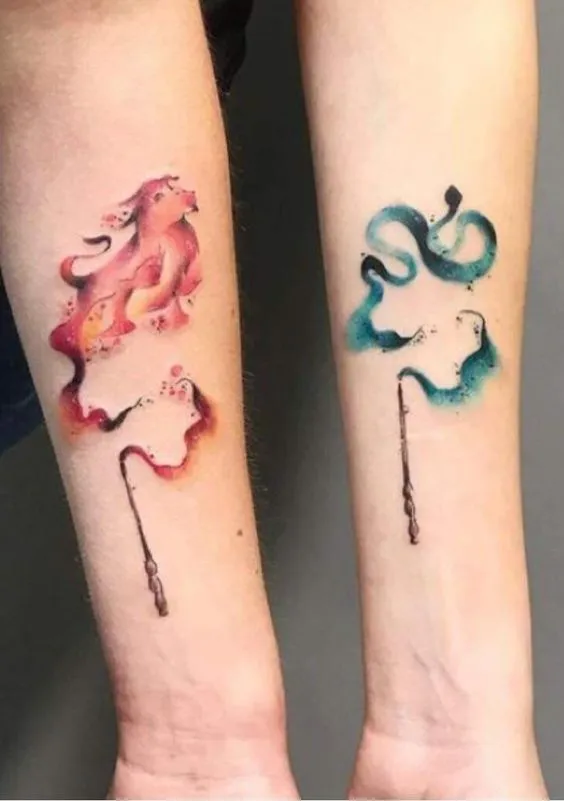 Tatuagem de varinhas Harry potter, uma na cor avermelhada representando Grifinória e a outra esverdeada representando Sonserina.