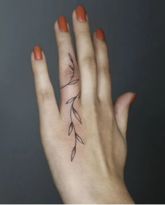 Tatuagem de planta delicada enrolada no dedo