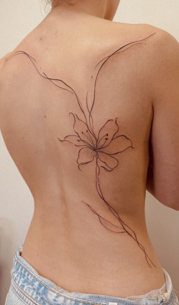 Tatuagem floral delicada fine line nas costas
